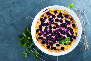 Cottage cheese casserole baked with blueberry. Curd casserole with fresh berries on kitchen table. Top view
