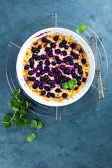 Cottage cheese casserole baked with blueberry. Curd casserole with fresh berries on kitchen table. Top view