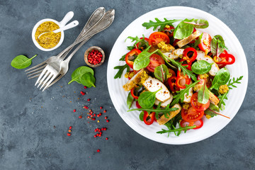 Fresh vegetable salad plate of tomatoes, spinach, pepper, arugula, chard leaves and grilled chicken breast. Fried chicken meat, fillet with salad. Healthy food. Diet dinner or lunch menu