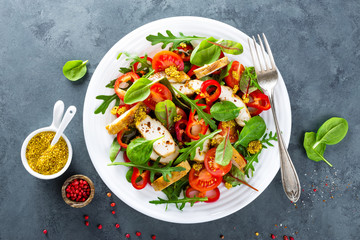Fresh vegetable salad plate of tomatoes, spinach, pepper, arugula, chard leaves and grilled chicken breast. Fried chicken meat, fillet with salad. Healthy food. Diet dinner or lunch menu