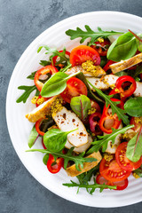 Fresh vegetable salad plate of tomatoes, spinach, pepper, arugula, chard leaves and grilled chicken breast. Fried chicken meat, fillet with salad. Healthy food. Diet dinner or lunch menu