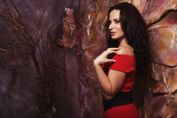 Obraz premium Sensual beautiful brunette woman posing in red dress. Art and fa