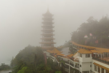 The Chin Swee Caves Temple over clouds and heavy fog. It's a Taoist temple in Pahang, Malaysia. The...