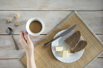 Butter and bread for breakfast, with cup of coffee.