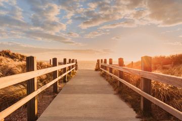 Holztreppe mit Blick auf das Meer beim Sonnenuntergang