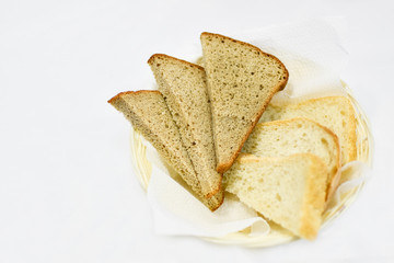 organic bread made from rye and wheat flour, pieces of bread are at the plate, on a white background