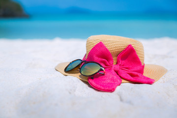 Straw hat and sun glasses on beach