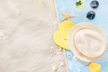 Travel vacation concept. Traveler accessories on sand. Straw hat, sunglasses, flip flops, cocktail,...