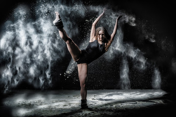 Obraz na płótnie Canvas Girl dansing with flour on black background