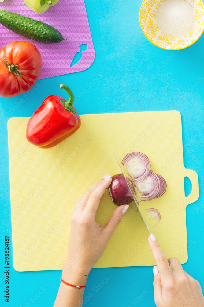 Canvas Prints Top view female prepare summer vegetarian salad on blue background. Healthy food concept. Diet food