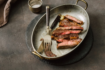 Slices juicy roast beef steak on vintage frying pan