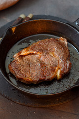 Close up juicy beef steak on vintage cast iron frying pan