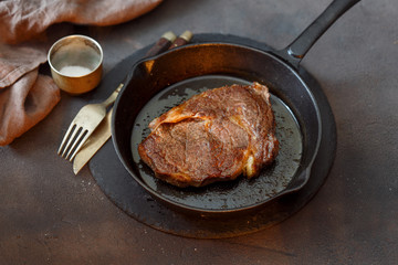 Juicy beef steak on a vintage cast iron frying pan