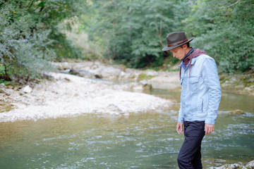 Fashionable explorer man walking by the river.