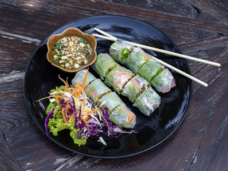 Fresh vietnamese spring rolls on a plate with salad