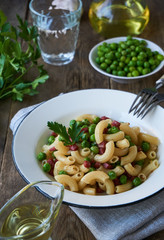 Pasta with green peas and sausage in a plate