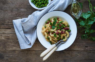 Pasta with green peas and sausage in a plate