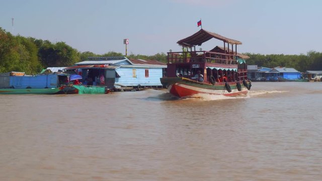 View of houses of floating village and boats with tourists