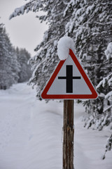 Warning road sign on a snowy winter forest road