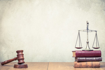 Wooden gavel, Vintage law scales and books on the desk front concrete wall background. Symbols of...