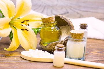 Natural herbal skin care products, top view ingredients coconut, lily flower, essence oil on table concept of the best all natural face moisturizer. Facial treatment preparation background