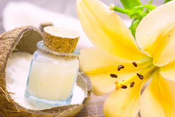 Natural herbal skin care products, top view ingredients coconut, lily flower, essence oil on table concept of the best all natural face moisturizer. Facial treatment preparation background