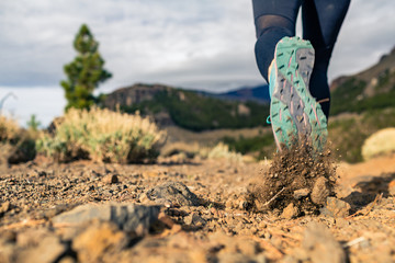 Sole of shoe walking in mountains on rocky footpath