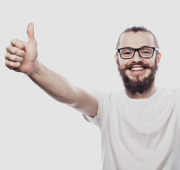 Fototapeta premium Portrait of a cheerful young bearded man showing okay gesture isolated on the white background