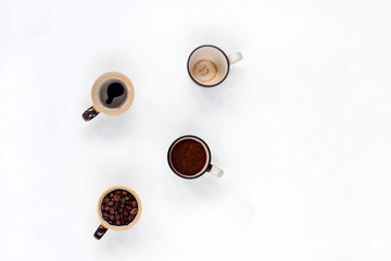 Cups with coffee beans, a rock and drunk a Cup on a white kitchen table.