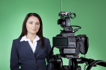 Television announcer isolated on green background in blur. A TV host presents news