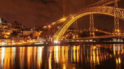 Fototapeta na wymiar Portugal, Porto, Luis I Bridge on a sunset, light and reflections^ long exposure shot