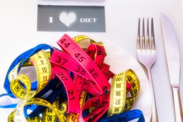 scale and plate of tape with cutlery. diet and slimming concept