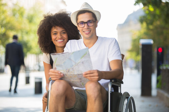 Portrait Of Young Couple Of Tourists Man In Wheelchair