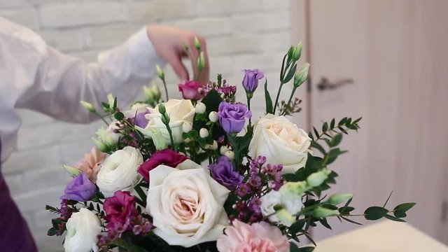 Close up of woman florist making bouquet at flower shop. People, small business, sale and floristry concept.