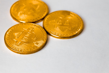 three gold coins bitcoins, lying on a white background