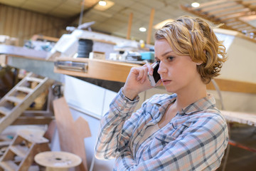 young woman on the phone in marine workshop