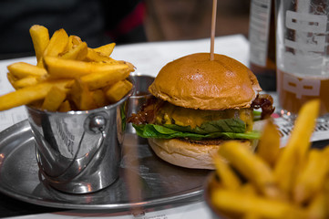 Fresh hamburger and fries on silver plate