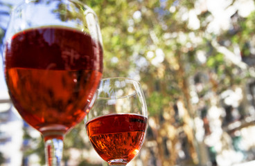 Obraz na płótnie Canvas two glasses of red wine on the table of a street cafe on a bright sunny day