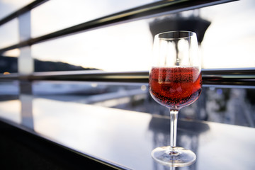 a glass of red wine on the balcony in the evening