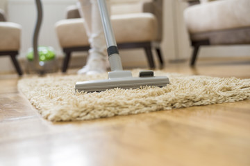 Close up of woman doing cleaning with vacuum cleaner