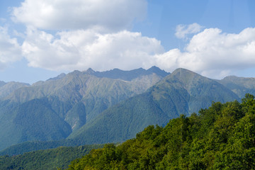 Scenic mountainous area against blue sky with clouds