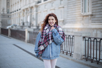 Attractive young girl in denim jacket and laughing on the street. 