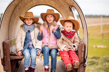 three sisters have fun on the farm near the old cart