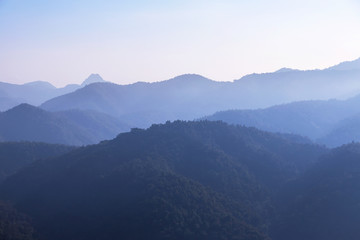 Fototapeta na wymiar sunrise white fog in early morning on high angle view of layer tropical mountains with at Thailand.