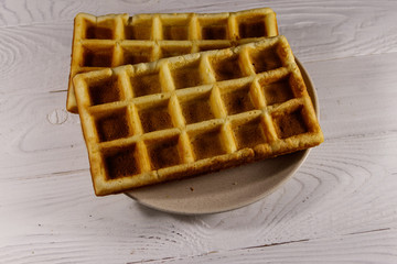 Belgian waffles on white wooden table. Top view