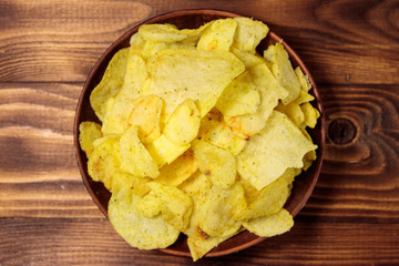 Plate of potato chips on wooden table