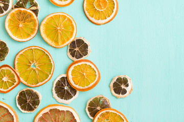 Top view on slices od different citrus fruit: grapefruit, lemon and orange on light turquoise background