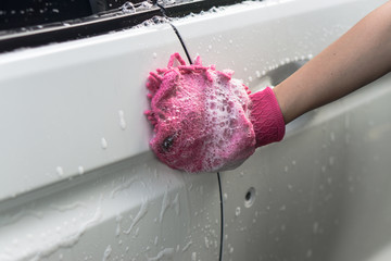 hand hold sponge over the car for washing
