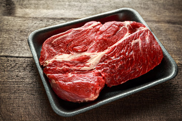 Fresh Raw braising steak on black tray