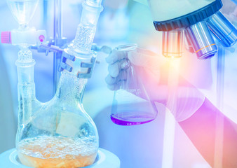 Microscope equipment with hand scientist holding flask and Distillation set with dropping funnels...